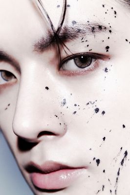 a close up of a person with black spots on his face