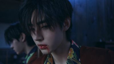a woman with blood on her face and a man in the background