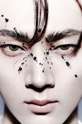 a close up of a person's face with hair and makeup