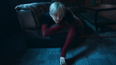 a woman sitting on a couch in a dark room