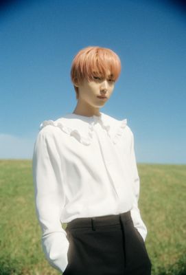 a woman with red hair standing in a field