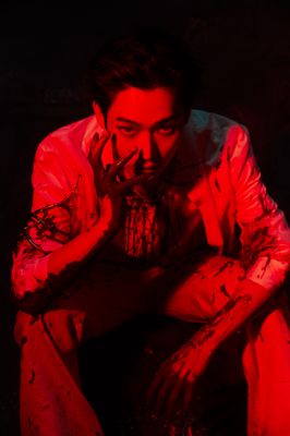 a man sitting in the dark with his hands on his face