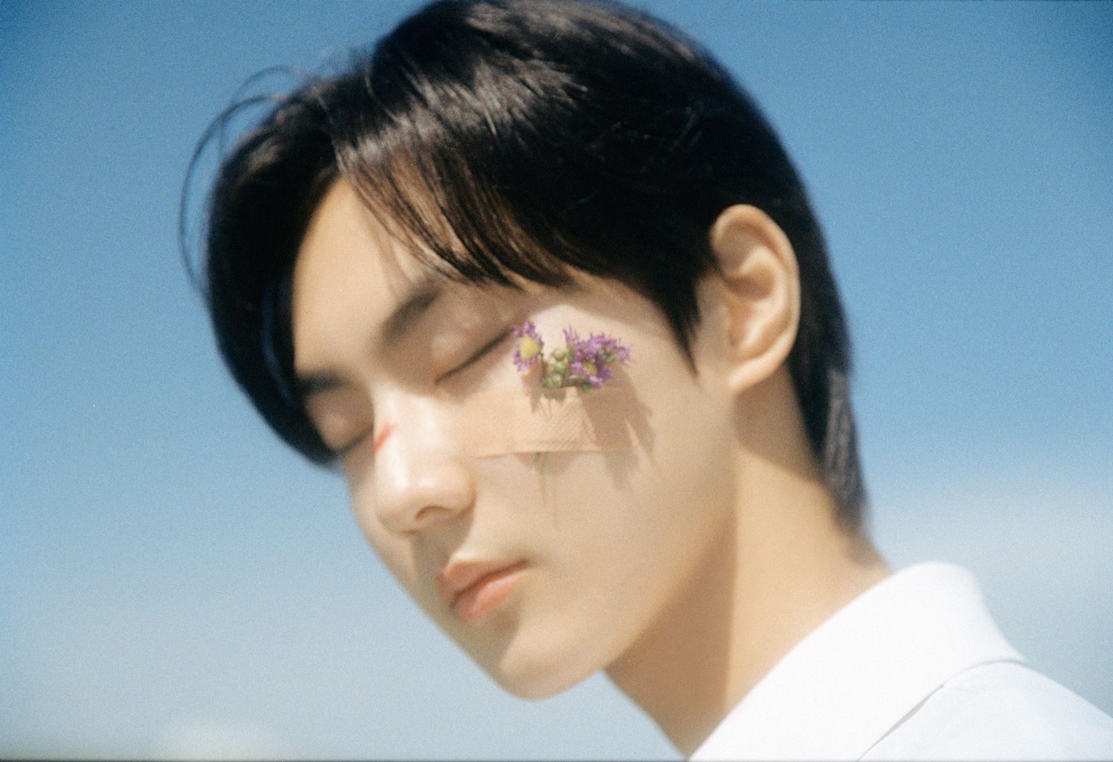 a man with a flower pinned to his forehead