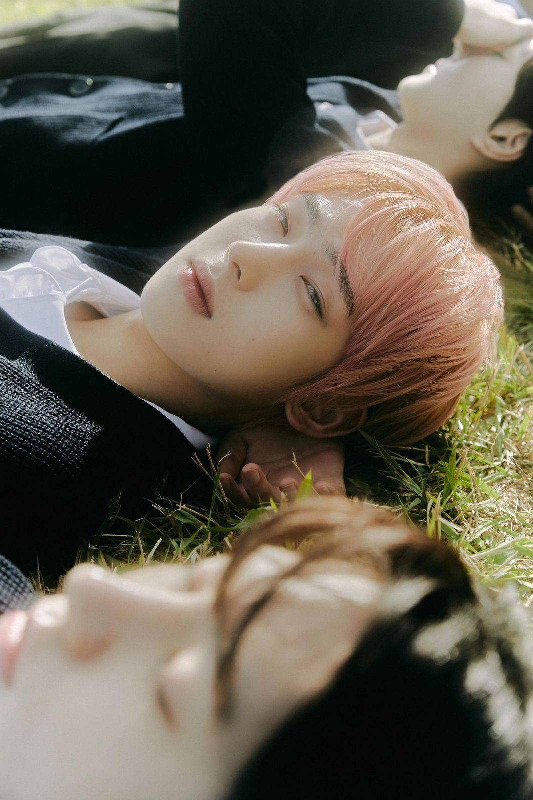 a couple of people laying on top of a lush green field