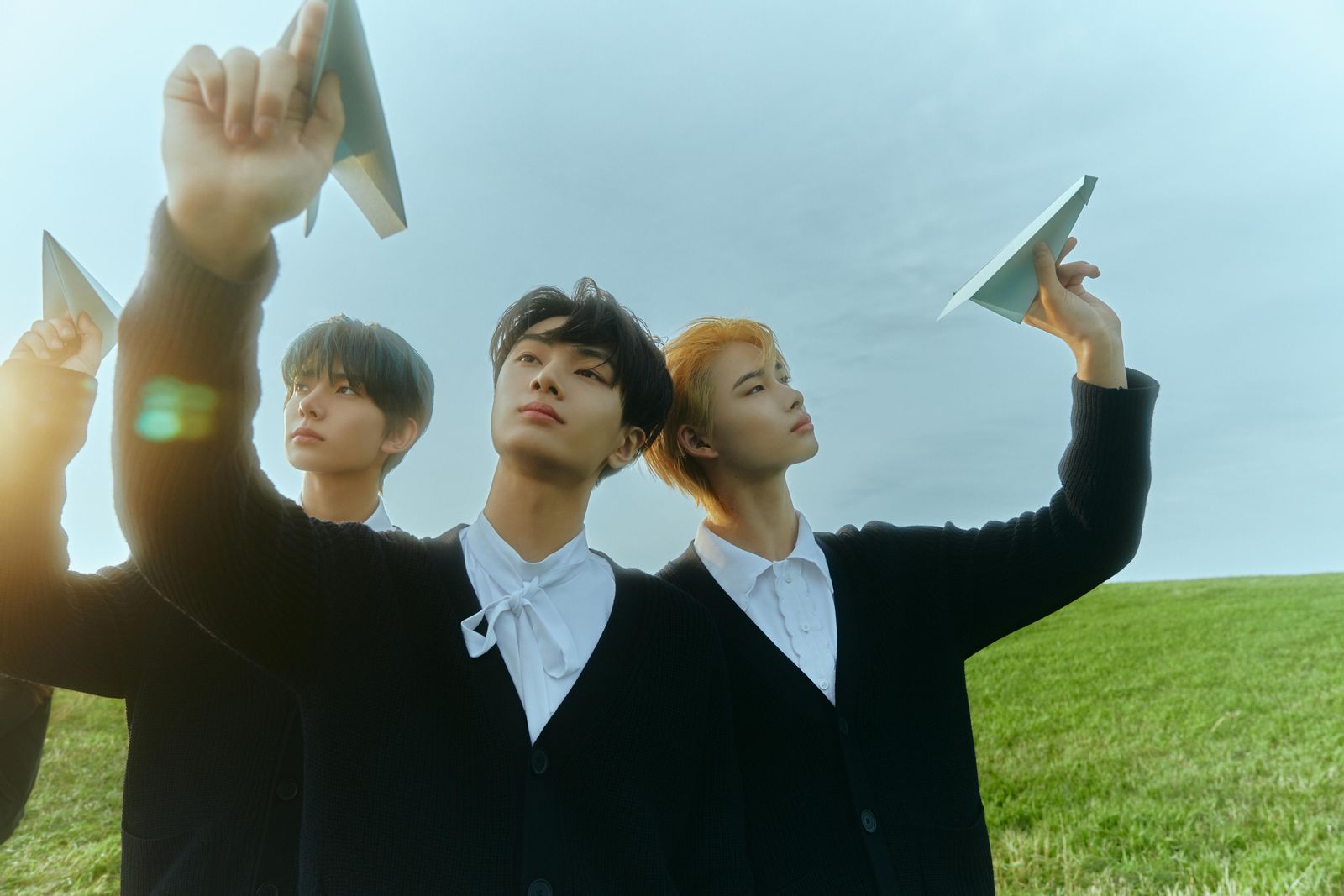 a group of young men standing on top of a lush green field