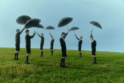 a group of people standing on top of a lush green field