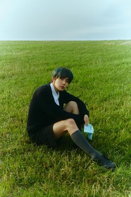 a person sitting in the grass with a book