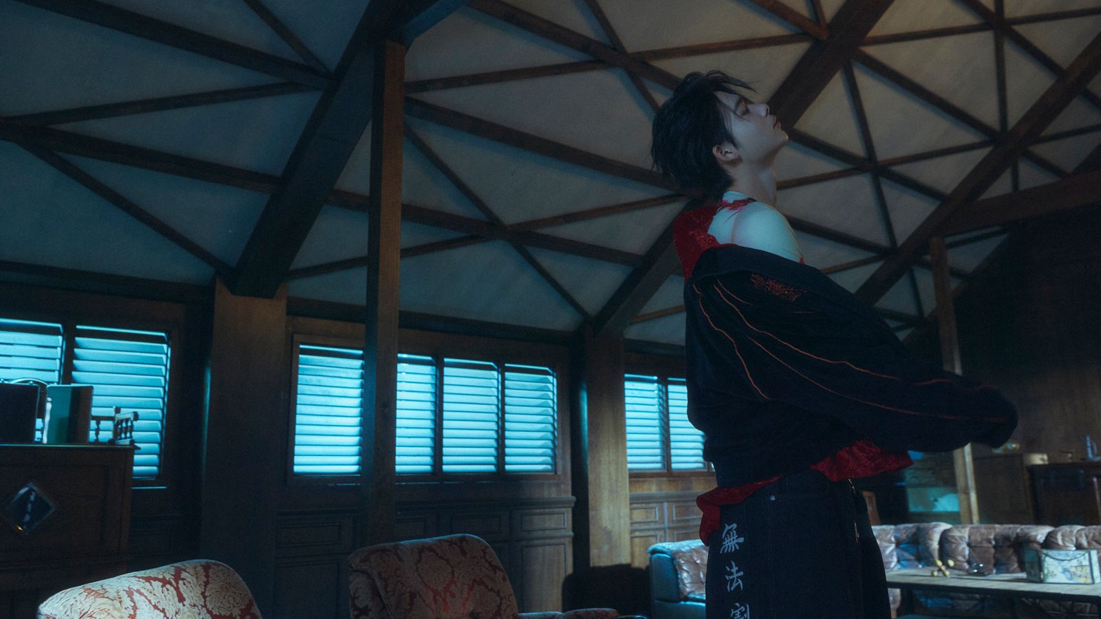 a man standing in a living room next to a window