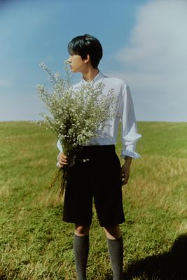 a man standing in a field holding a plant