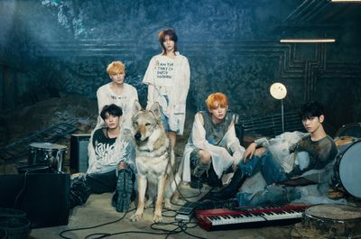 a group of young men sitting next to a dog