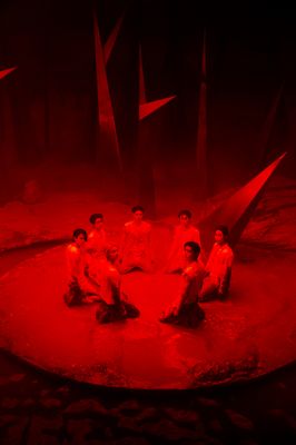 a group of people sitting on top of a red floor