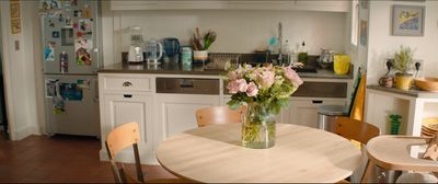 a vase of flowers on a table in a kitchen