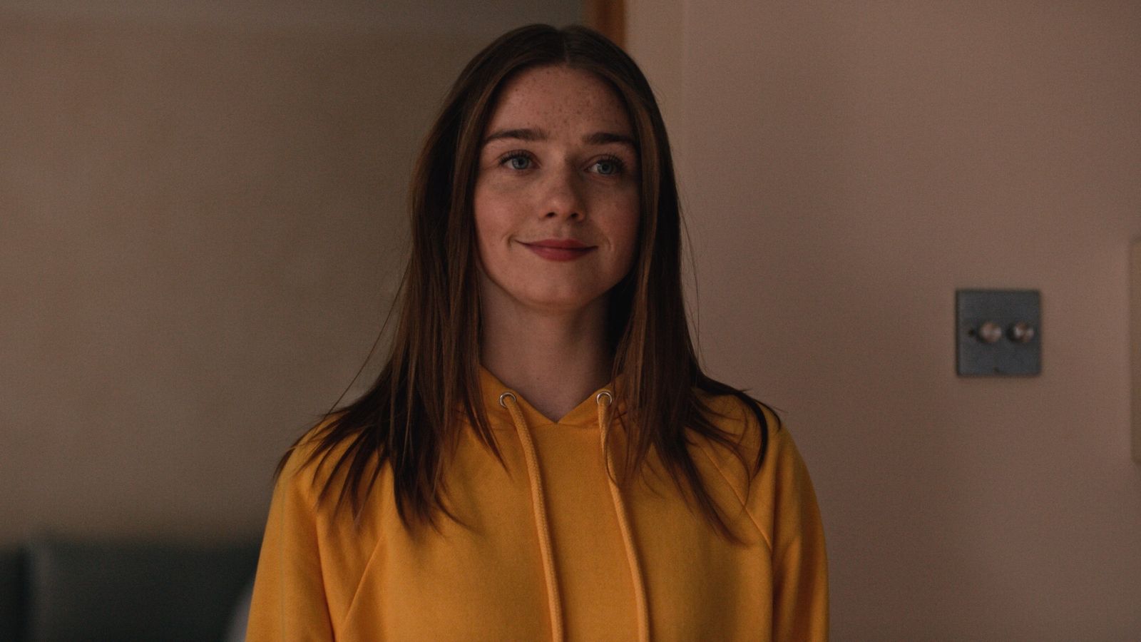 a woman in a yellow shirt standing in a room