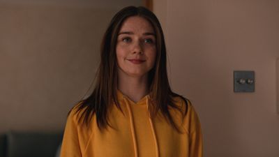 a woman in a yellow shirt standing in a room