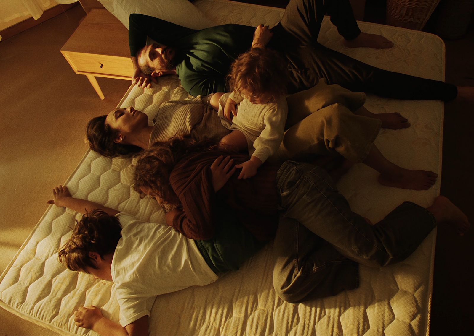 a group of people laying on top of a mattress