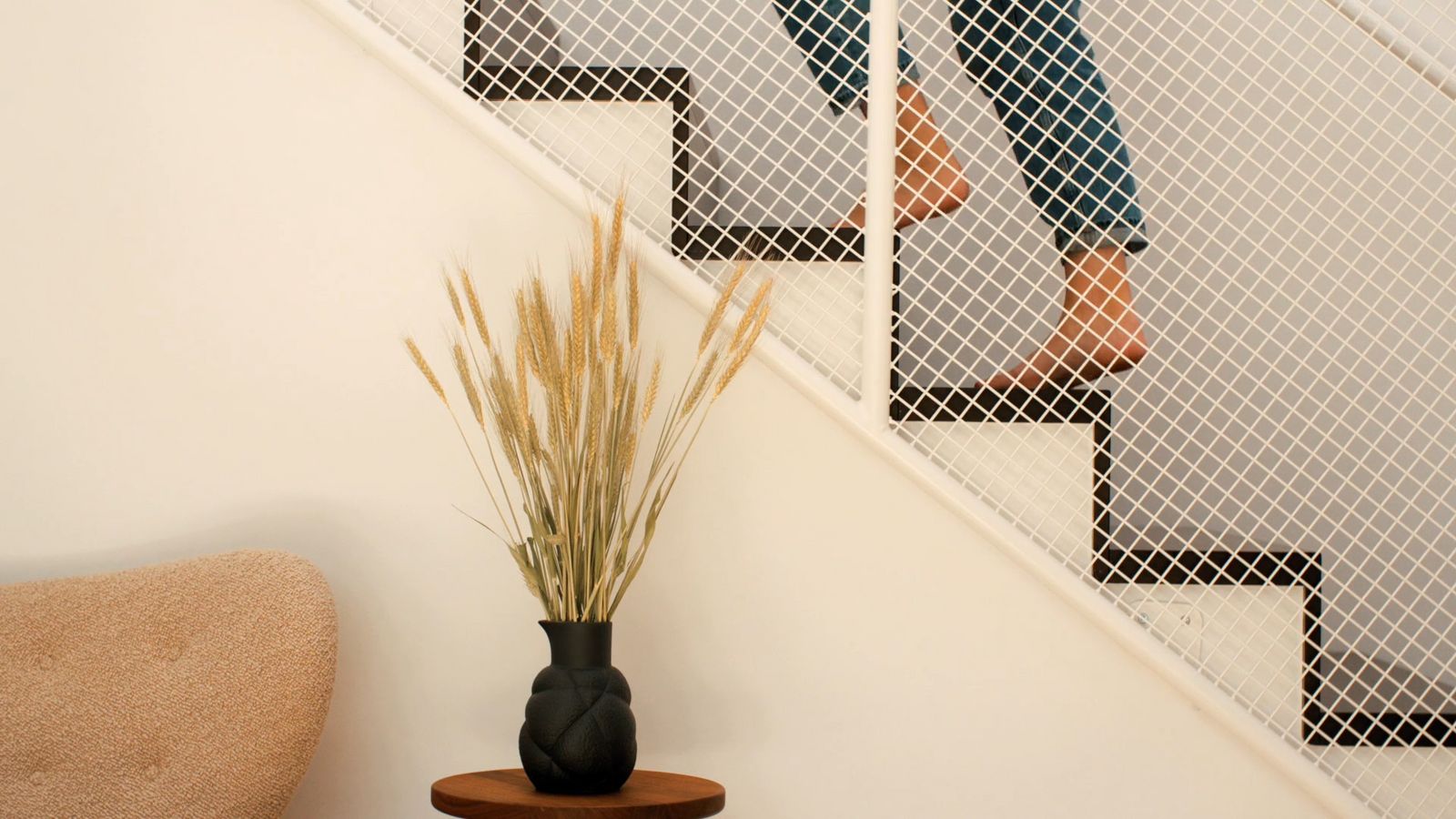 a vase with a plant next to a stair case