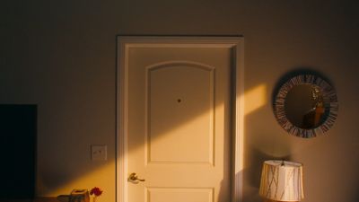 a white door in a room next to a lamp