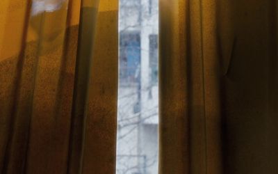 a window with yellow curtains and a window sill in the background