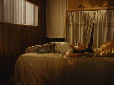 a woman laying on top of a bed next to a window