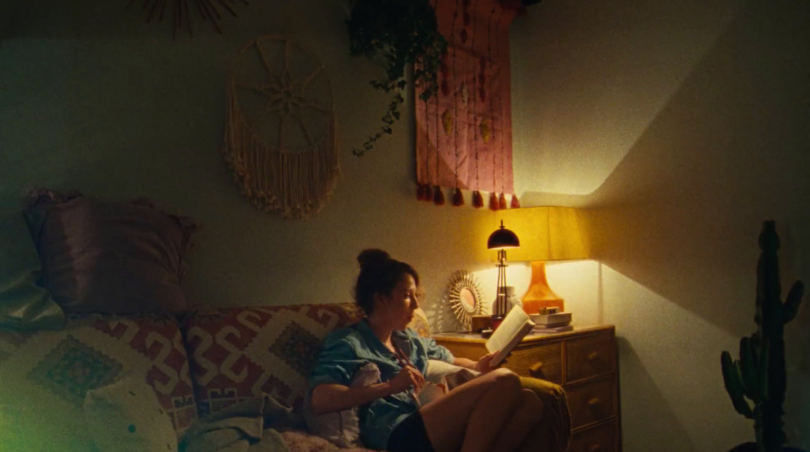 a woman sitting on a couch reading a book