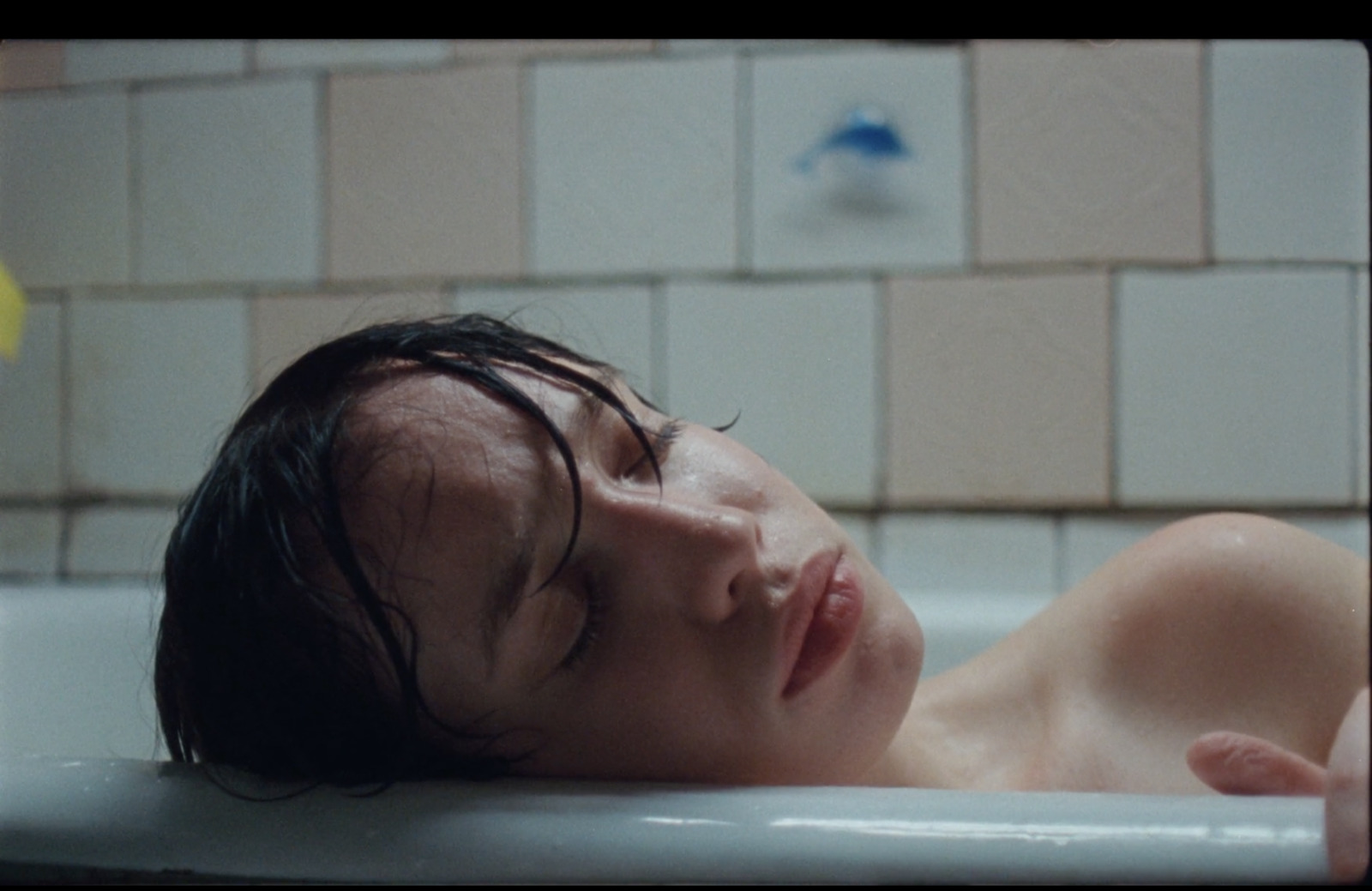 a young man laying down in a bathtub