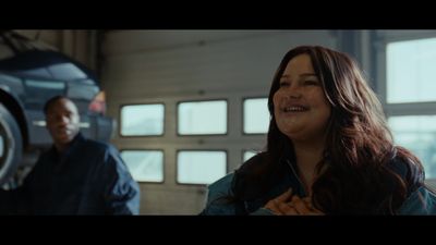 a woman standing next to a man in a garage