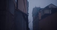 a narrow alley way with a clock tower in the distance