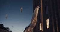 a group of kites flying over a city street