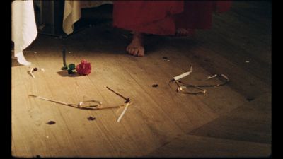 a person standing on a wooden floor next to a pair of scissors