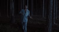 a man standing in the middle of a forest at night