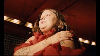 a woman in a red dress with a tattoo on her arm