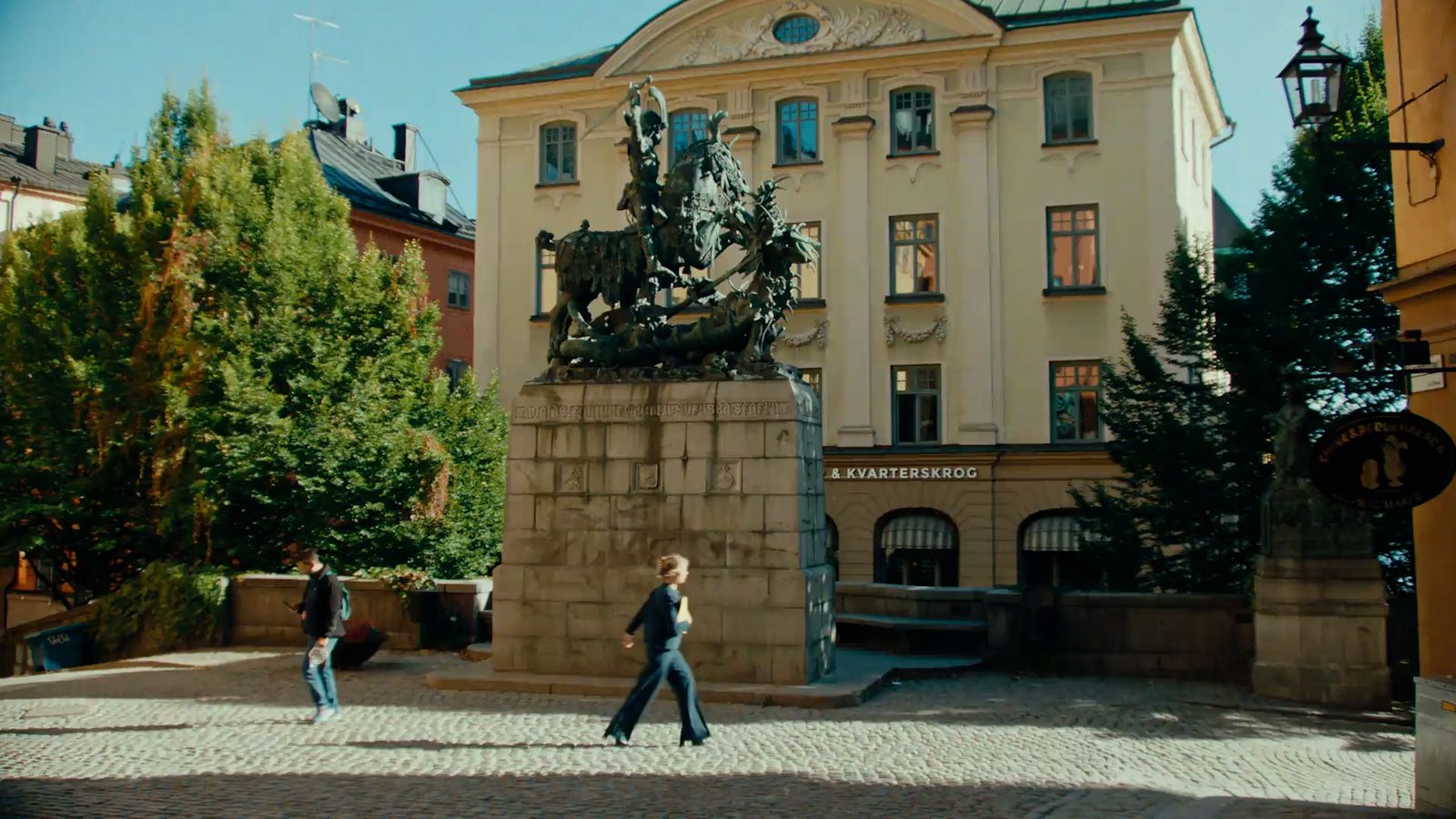 two people walking in front of a large building