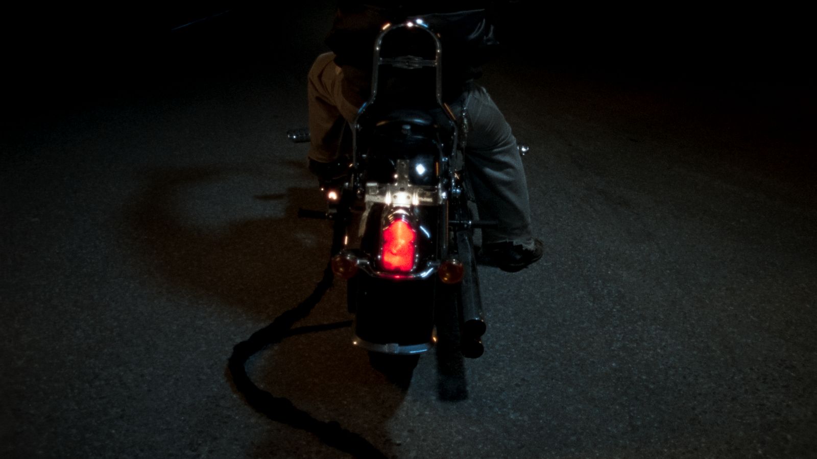 a person riding a motorcycle in the dark