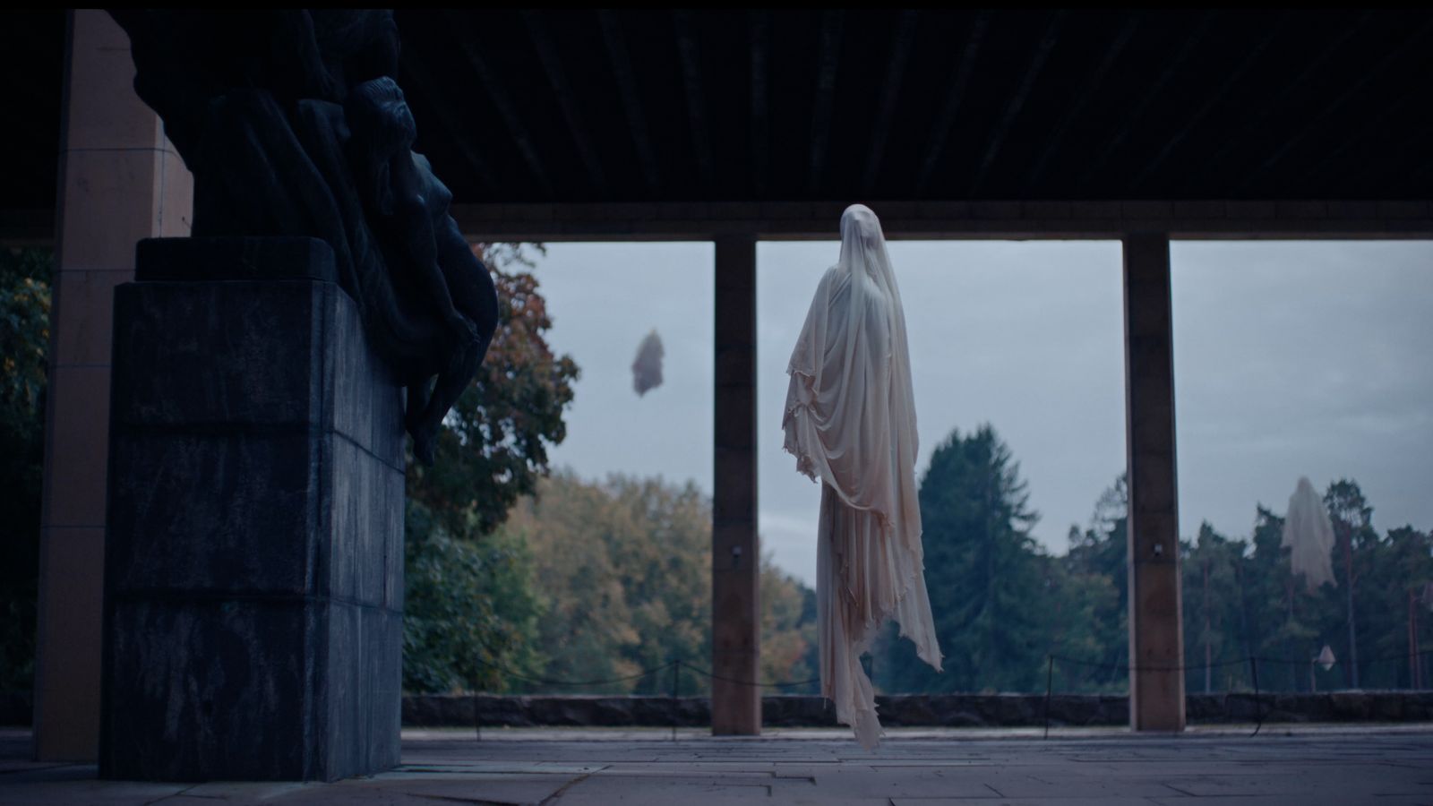 a statue of a ghost hanging from a building