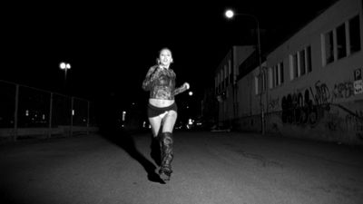 a woman running down a street at night