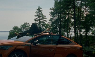 an orange car with a statue on top of it