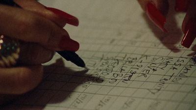 a person writing on a piece of paper with a pen