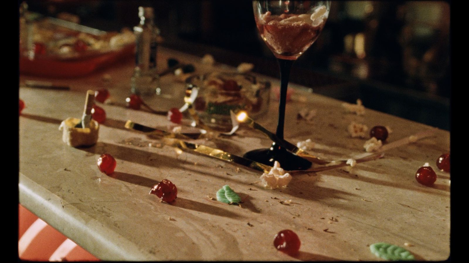 a table topped with lots of candy and a wine glass