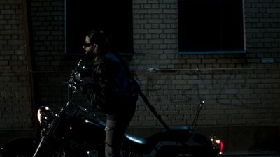 a man standing next to a parked motorcycle