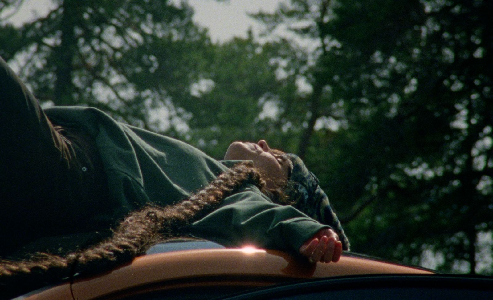 a woman with braids on top of a car