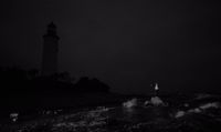 a black and white photo of a lighthouse at night