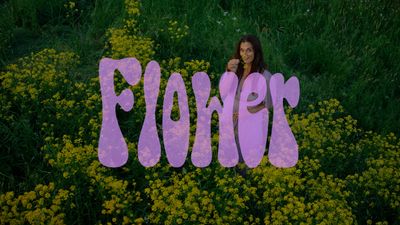 a woman holding a sign that says flowers