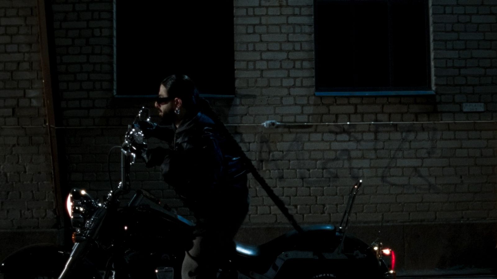 a man standing next to a motorcycle in the dark