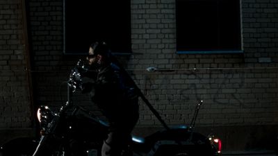 a man standing next to a motorcycle in the dark