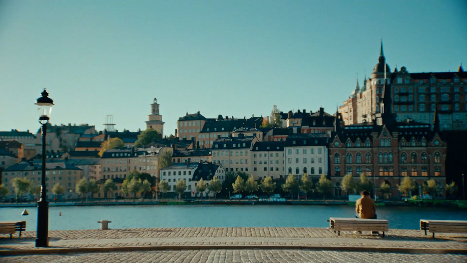 a person sitting on a bench near a body of water