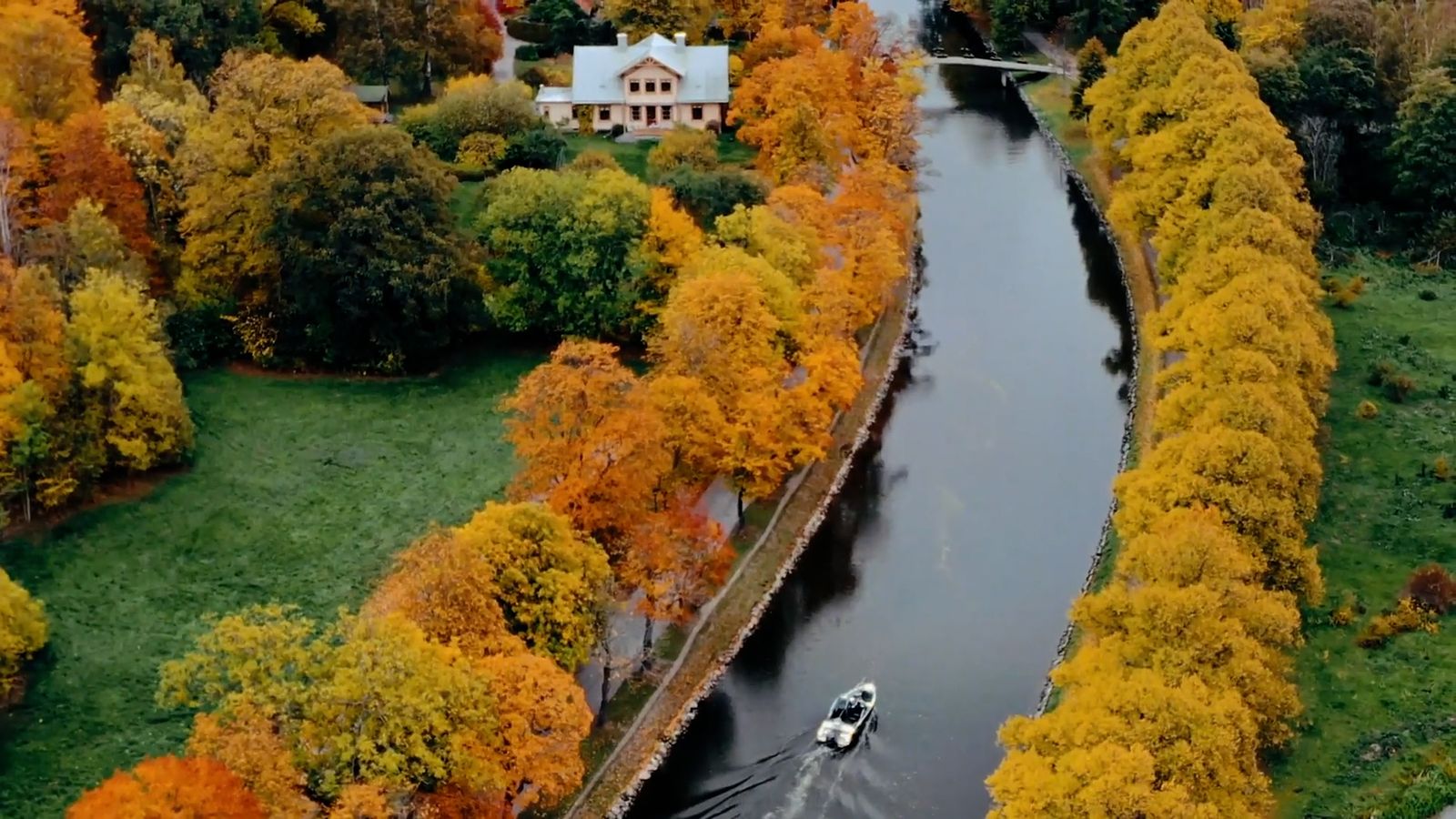 a boat traveling down a river surrounded by trees