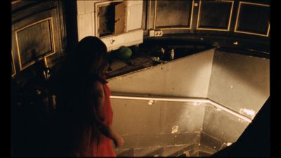 a woman in a red dress standing in a kitchen