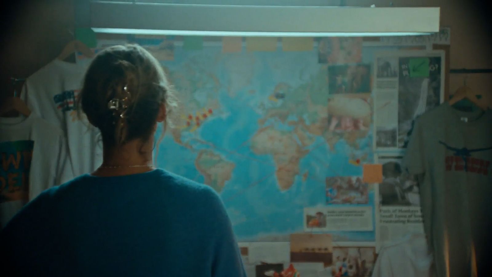 a woman standing in front of a map of the world