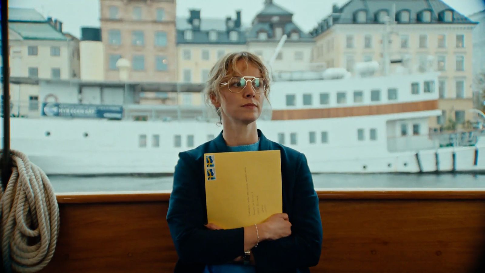 a woman sitting on a bench holding a yellow folder