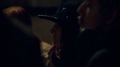 a woman wearing a hat in a dark room